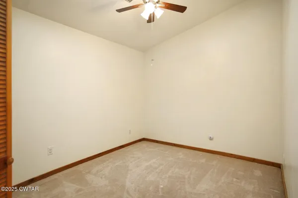 a view of a room with a ceiling fan and a window