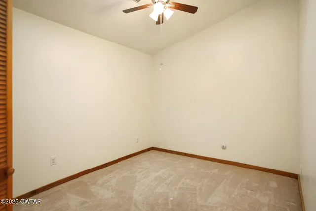 a view of a room with a ceiling fan and a window
