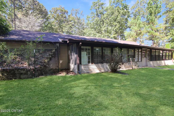 a view of a chair and table in backyard of the house