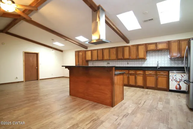 a kitchen with stainless steel appliances granite countertop a stove a sink and a refrigerator