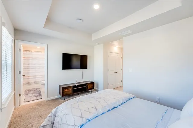 a bedroom with a bed and a large window