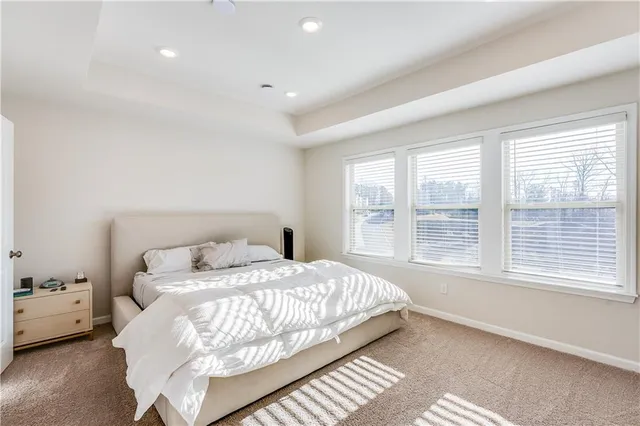 a bedroom with a large bed and a chandelier