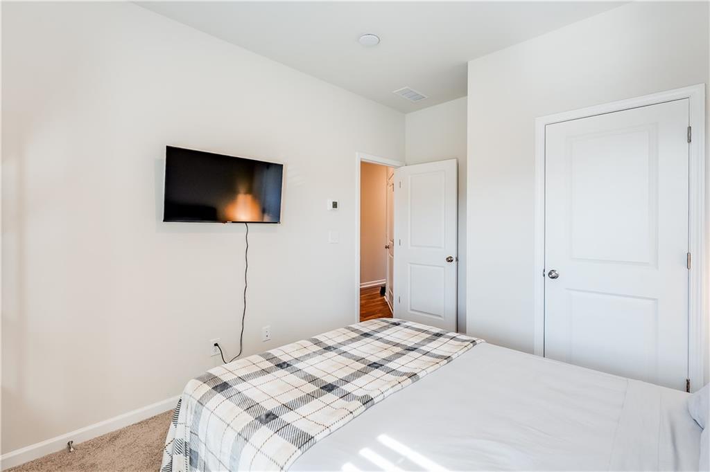 1634 Halbrook Place Southwest Marietta, GA 30008 - Photo 28 of 34 a bedroom with a bed and a flat screen tv