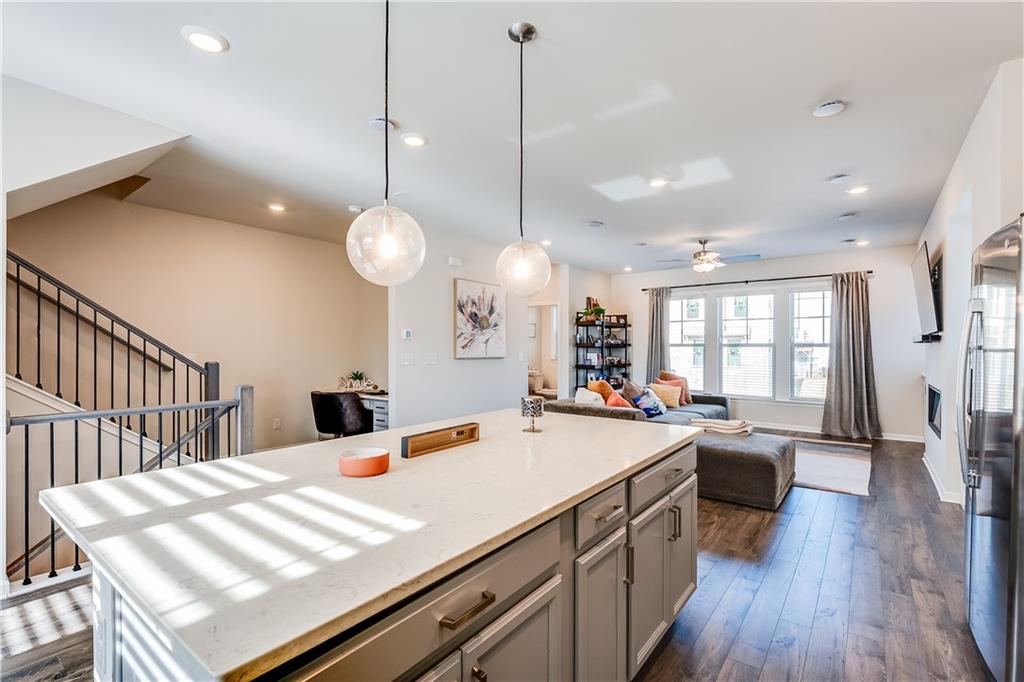 1634 Halbrook Place Southwest Marietta, GA 30008 - Photo 5 of 34 a large kitchen with kitchen island a stove a sink a dining table and chairs with wooden floor