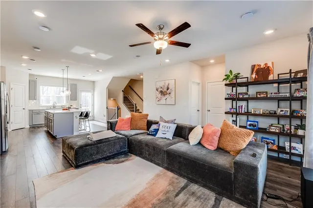 a living room with furniture a flat screen tv and kitchen view