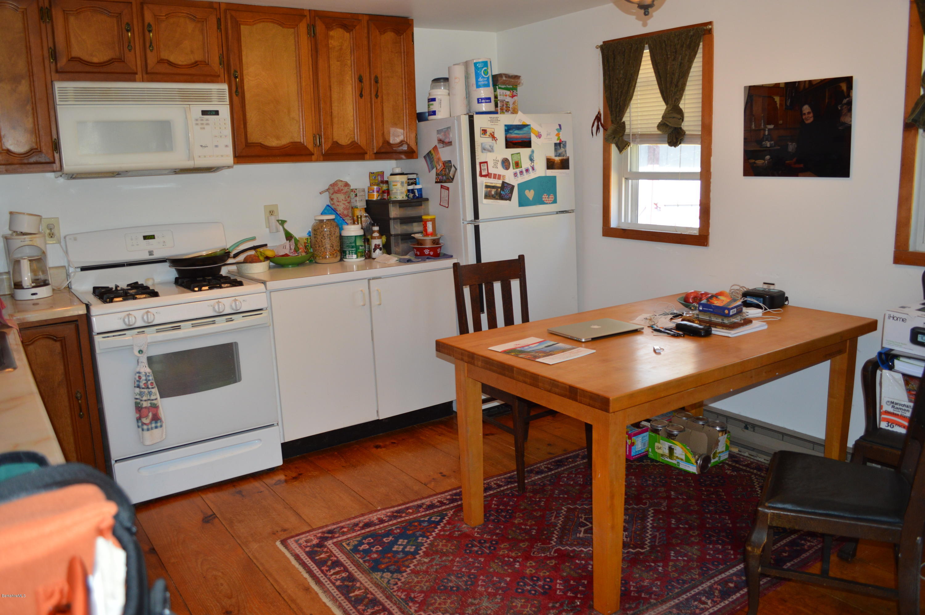 81 Peterson Road Becket, MA 01223 - Photo 18 of 24 a kitchen with stainless steel appliances wooden floor dining table and chairs