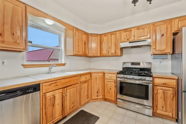 a kitchen with stainless steel appliances granite countertop a stove a sink and a microwave