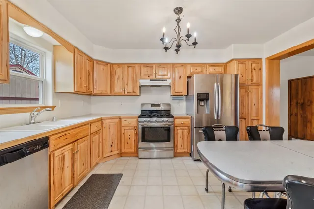a kitchen with stainless steel appliances a stove sink and white cabinets