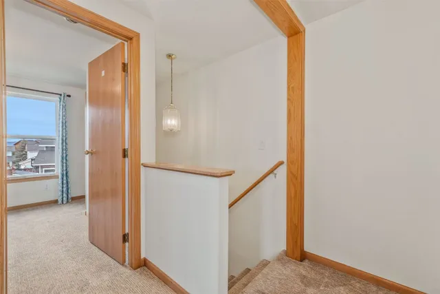 a view of a hallway with closet and a bathroom