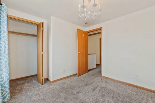 an empty room with a chandelier fan