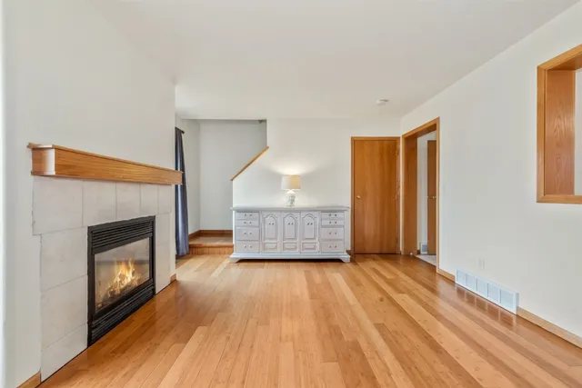a view of a livingroom with wooden floor and a fireplace