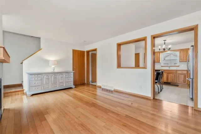 a view of an empty room with glass door and wooden floor