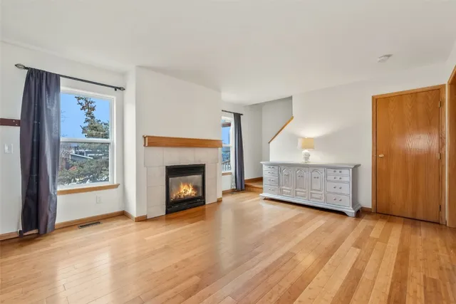a view of empty room with wooden floor and fireplace