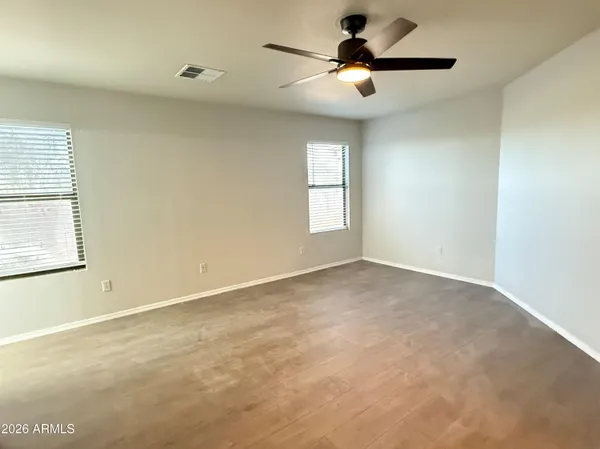 an empty room with closet and a chandelier fan