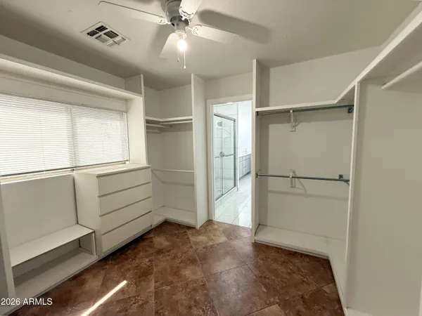 an empty room with windows and fan