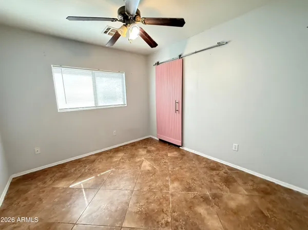 an empty room with closet and a chandelier fan