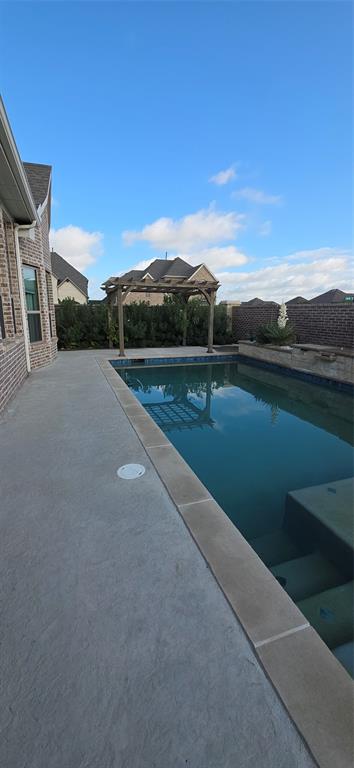 2000 Johnson Road Mansfield, TX 76063 - Photo 19 of 27 Spacious concrete patio with an adjacent rectangular swimming pool, featuring a stone coping and integrated steps