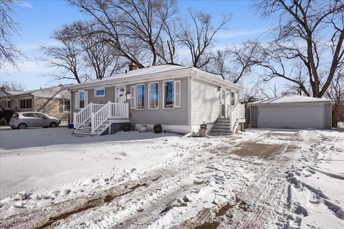 a front view of a house with a yard covered in snow