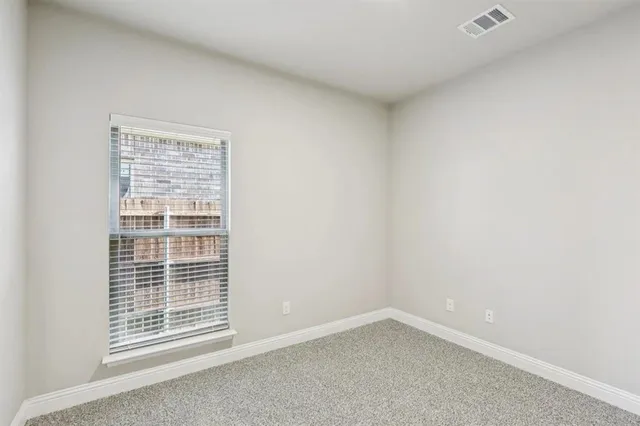 an empty room with chandelier fan