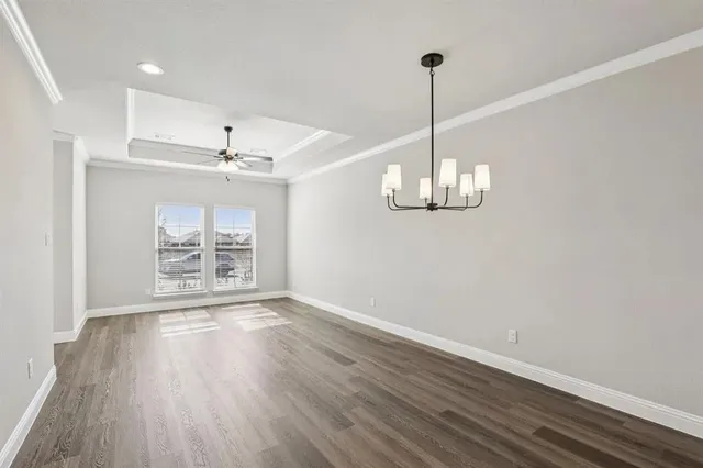 a view of a room with wooden floor chandelier and window