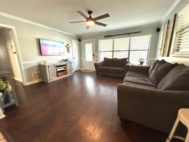 a living room with furniture flat screen tv and wooden floor