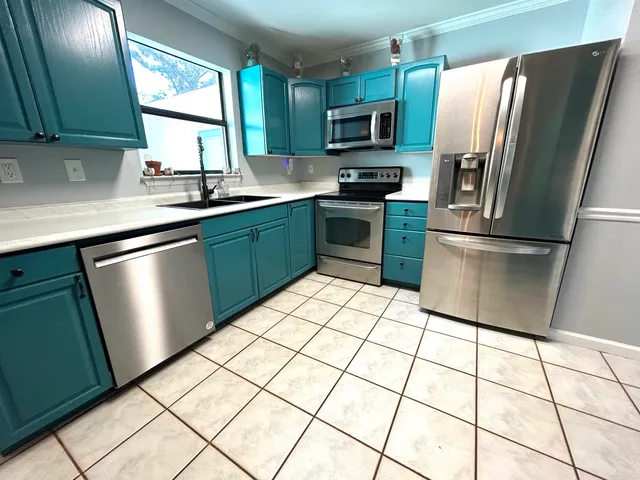 a kitchen with stainless steel appliances a refrigerator sink and microwave