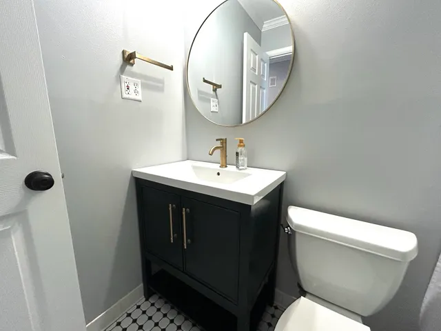 a bathroom with a sink a toilet and a mirror