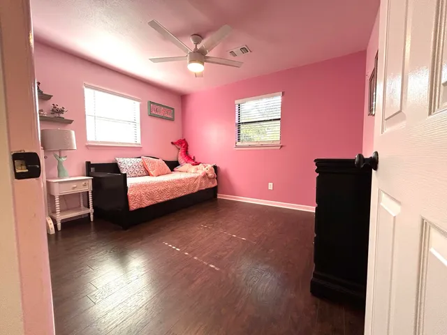 a spacious bedroom with a bed and a chandelier