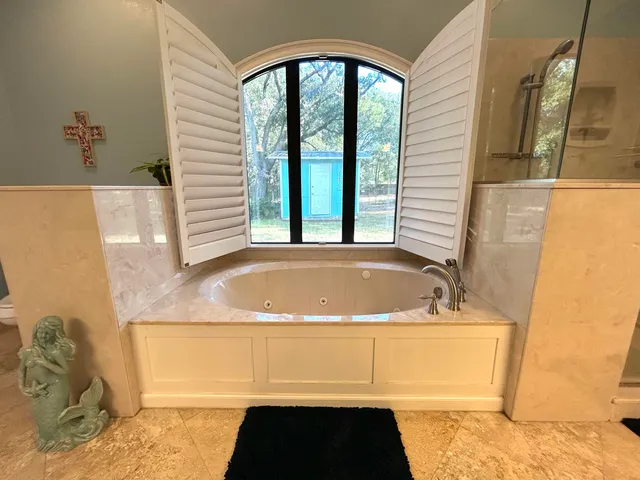 a bathroom with a tub sink and mirror