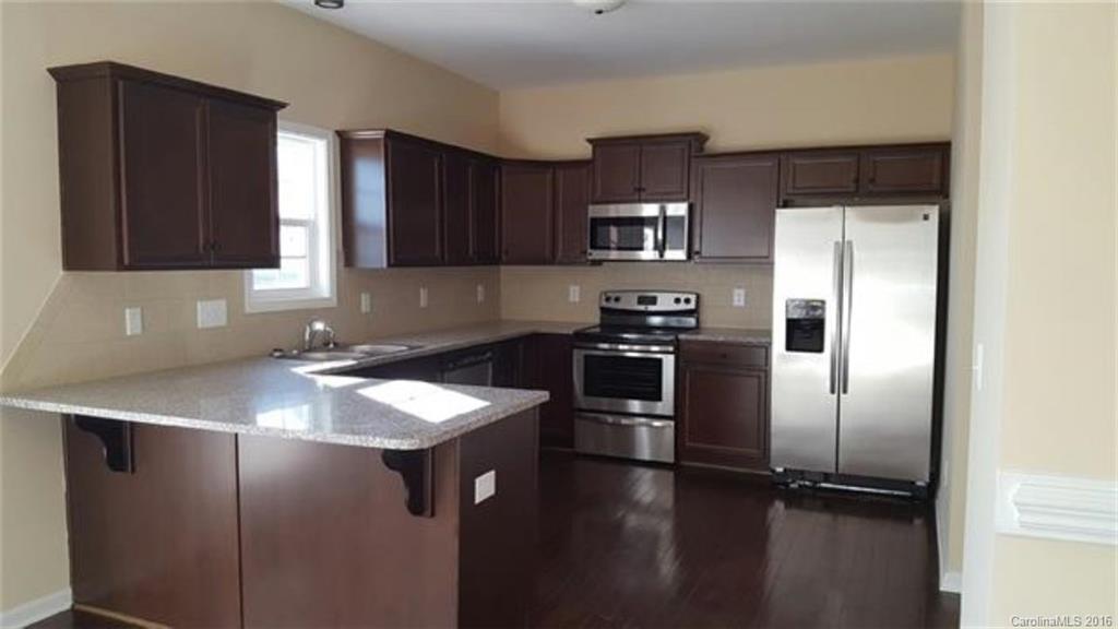 617 School House Lane, Unit 29 Fort Mill, SC 29708 - Photo 5 of 13 a kitchen with kitchen island a counter top space cabinets and stainless steel appliances