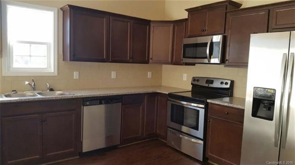 617 School House Lane, Unit 29 Fort Mill, SC 29708 - Photo 6 of 13 a kitchen with stainless steel appliances granite countertop a stove microwave refrigerator sink and cabinets
