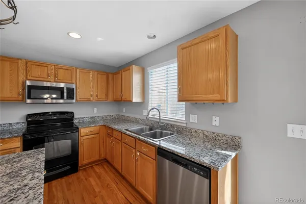 a kitchen with granite countertop stainless steel appliances a stove sink and microwave