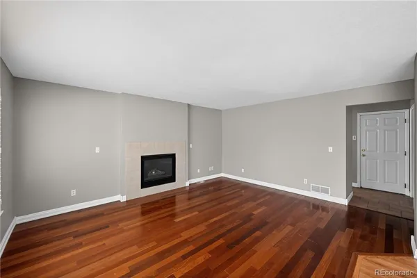 a view of empty room with wooden floor and fireplace