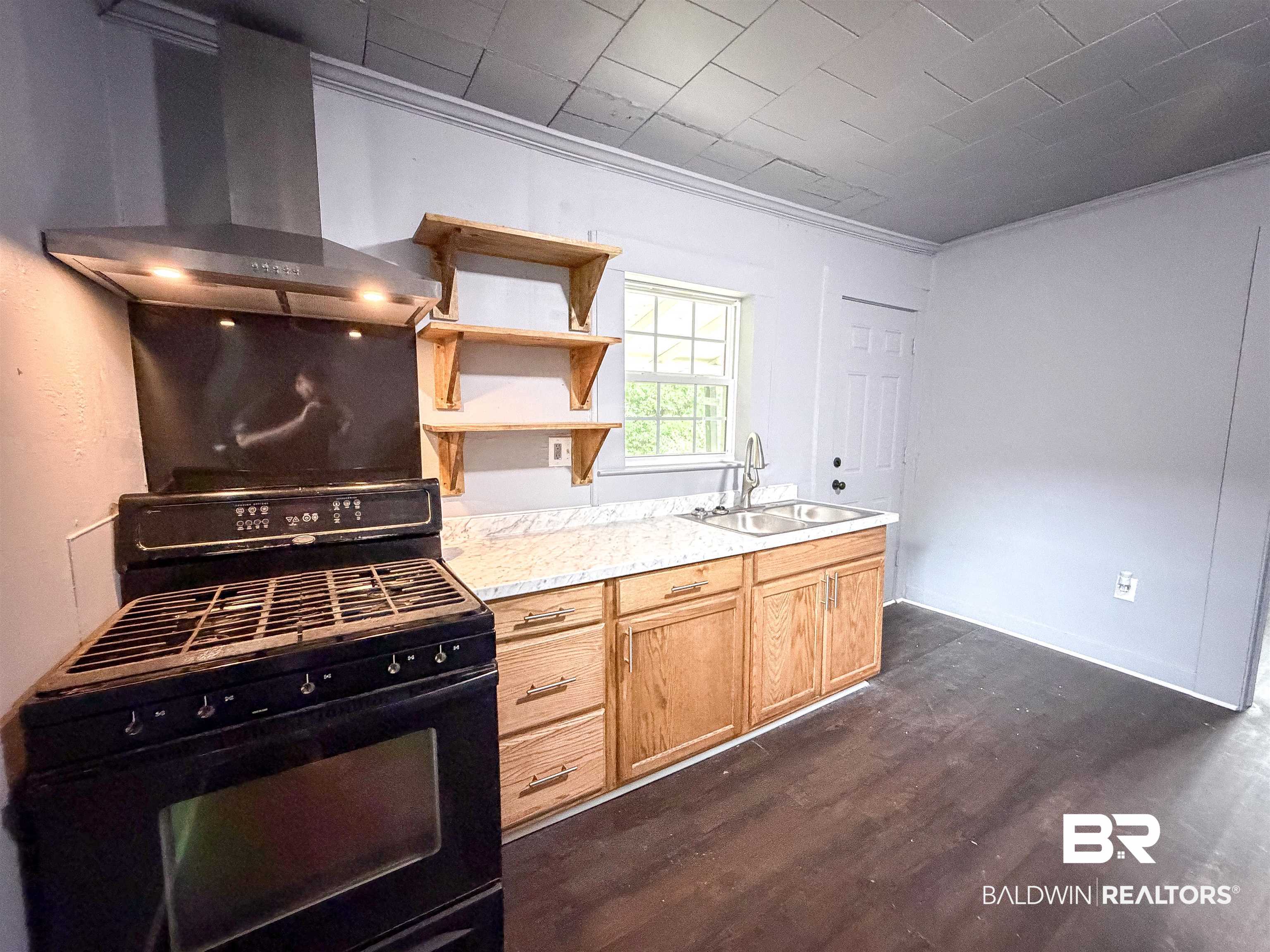 38 Flock Avenue Mobile, AL 36610 - Photo 9 of 27 Kitchen featuring dark wood-finish flooring, light gray walls, and a patterned ceiling
