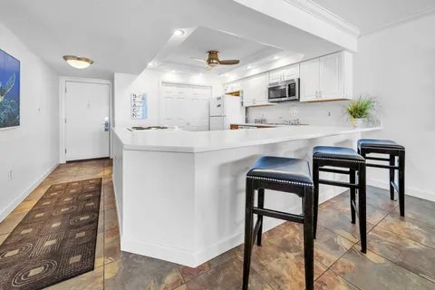 a kitchen with stainless steel appliances a table chairs refrigerator and microwave