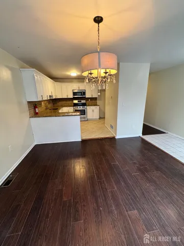 a view of a kitchen with a sink dishwasher a refrigerator and wooden floor