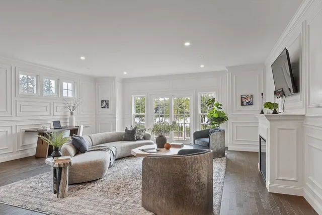 a living room with furniture flat screen tv and a large window