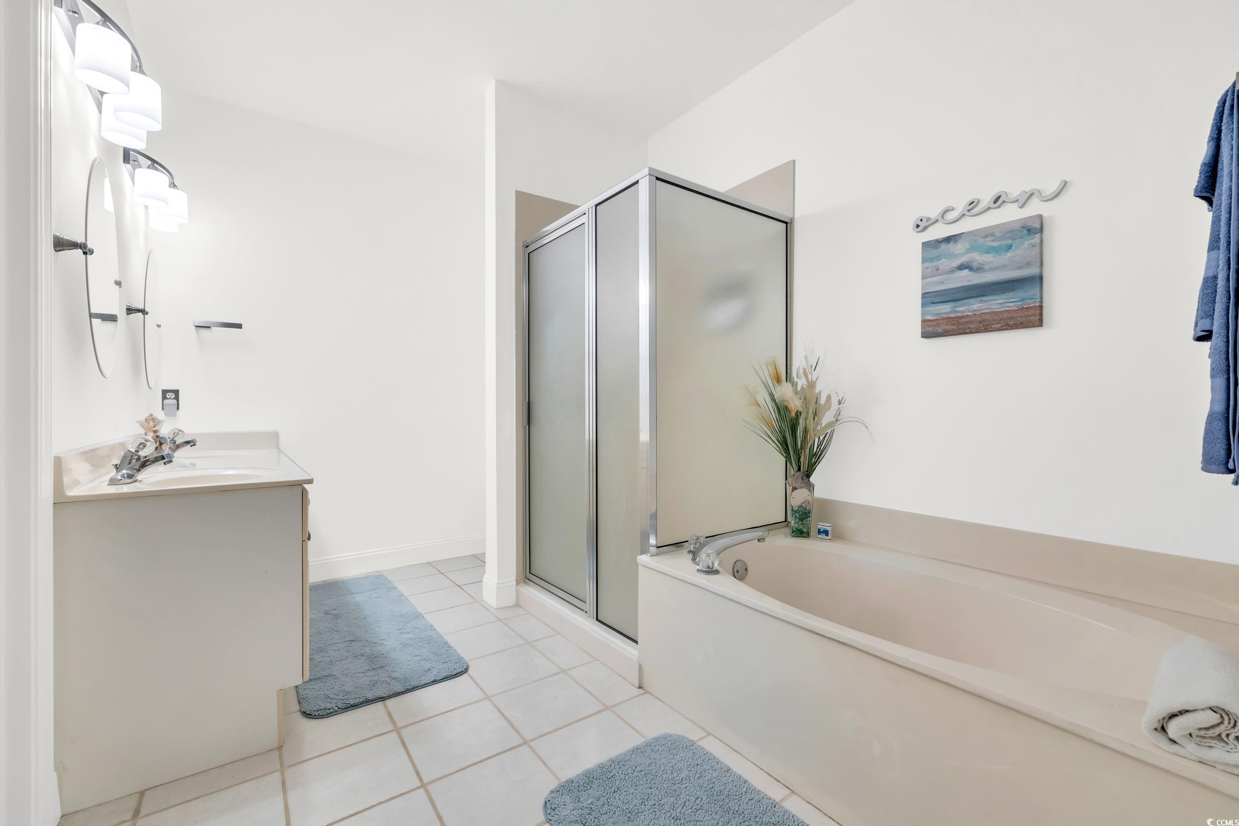 141 Twelve Oaks Drive, Unit 5 Pawleys Island, SC 29585 - Photo 19 of 37 Bathroom featuring vanity, light tile patterned floors, a shower stall, and a bath