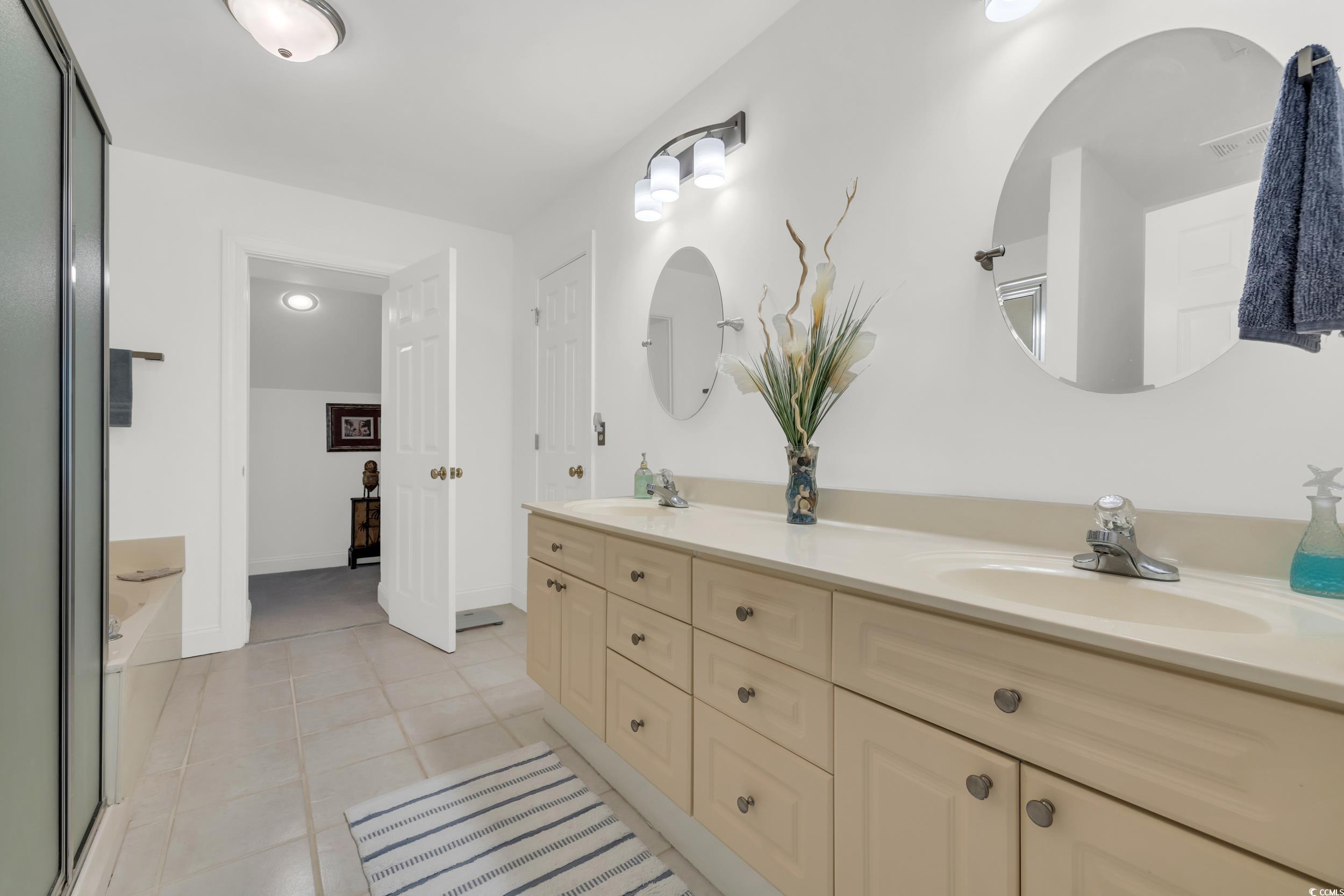 141 Twelve Oaks Drive, Unit 5 Pawleys Island, SC 29585 - Photo 25 of 37 Bathroom featuring double vanity, light tile patterned floors, a bath, and a shower with door