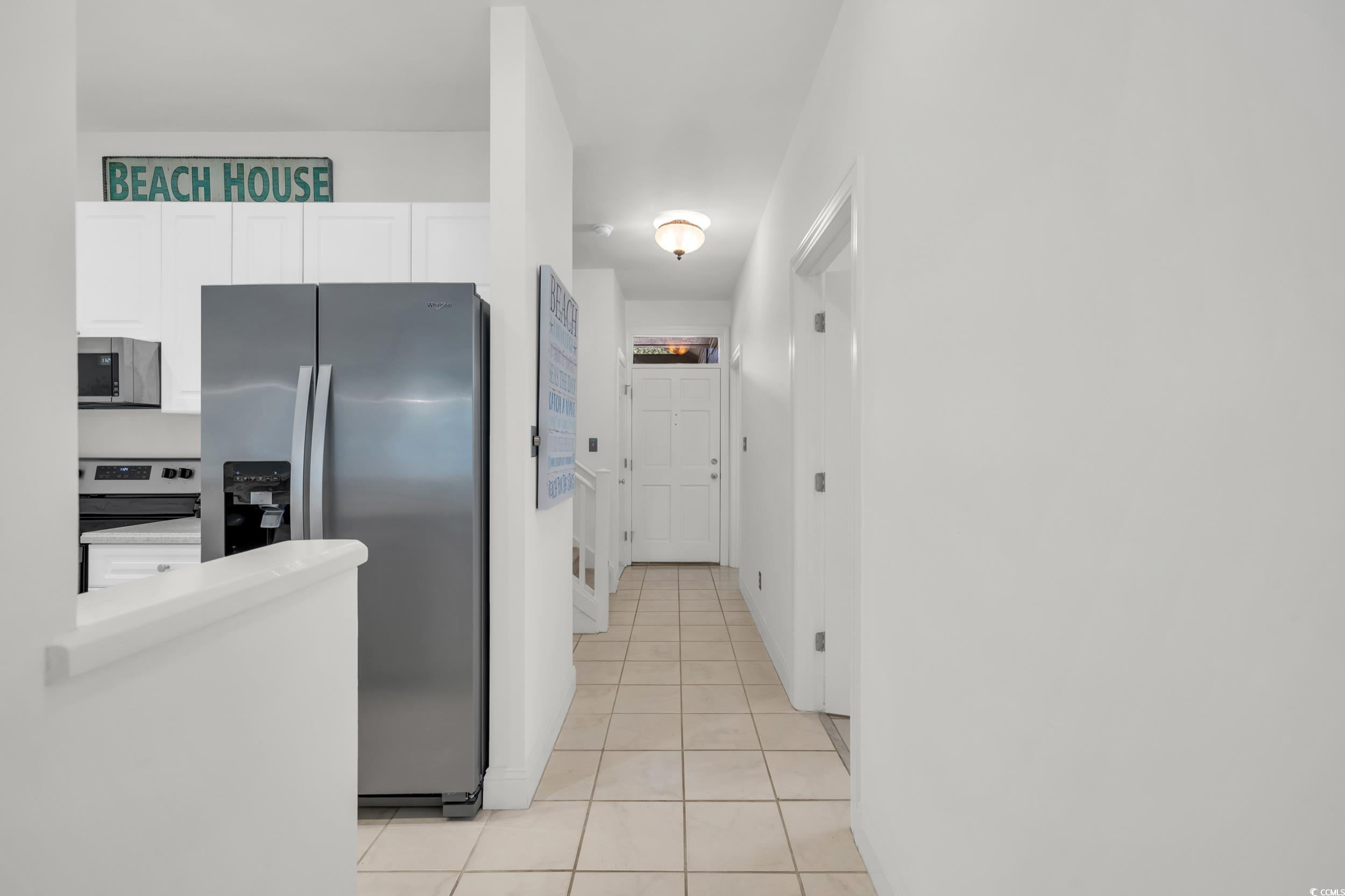 141 Twelve Oaks Drive, Unit 5 Pawleys Island, SC 29585 - Photo 6 of 37 Kitchen featuring stainless steel appliances, white cabinets, and light tile patterned flooring