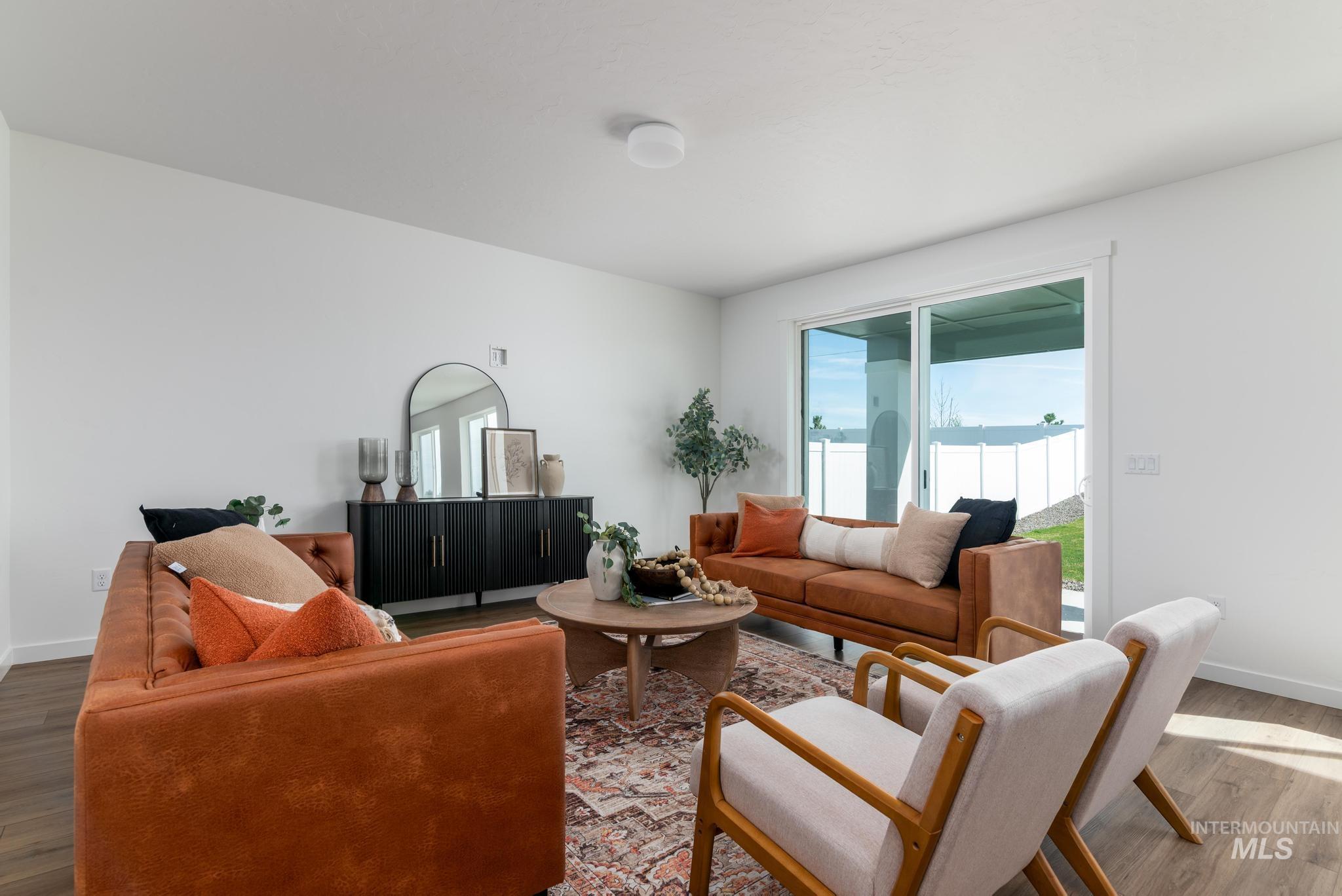 14817 Wing Spread Drive Caldwell, ID 83607 - Photo 2 of 19 Open-concept living space featuring wood-finish flooring, white walls, and a sliding glass door to the exterior