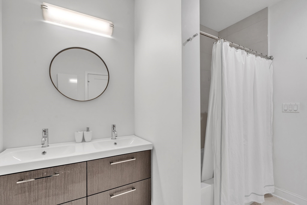 1 Brook Road, Unit 215 Quincy, MA 02169 - Photo 14 of 24 a bathroom with a double vanity sink and a mirror