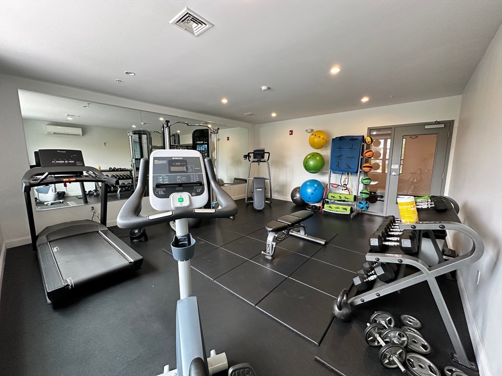 1 Brook Road, Unit 215 Quincy, MA 02169 - Photo 15 of 24 a room with gym equipment and wooden floor