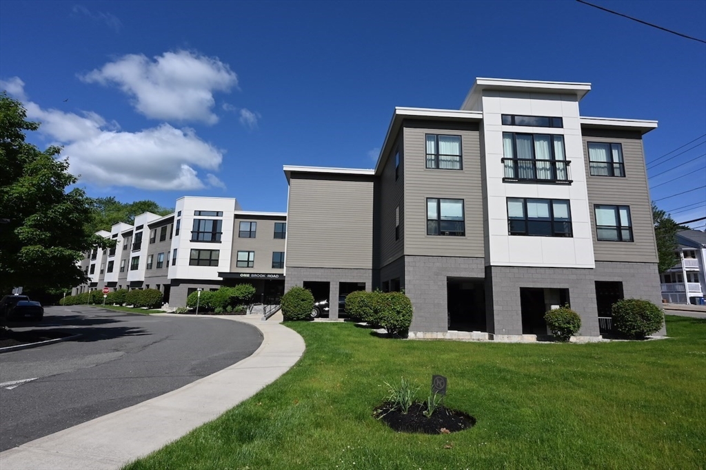 1 Brook Road, Unit 215 Quincy, MA 02169 - Photo 19 of 24 a front view of a building with a yard