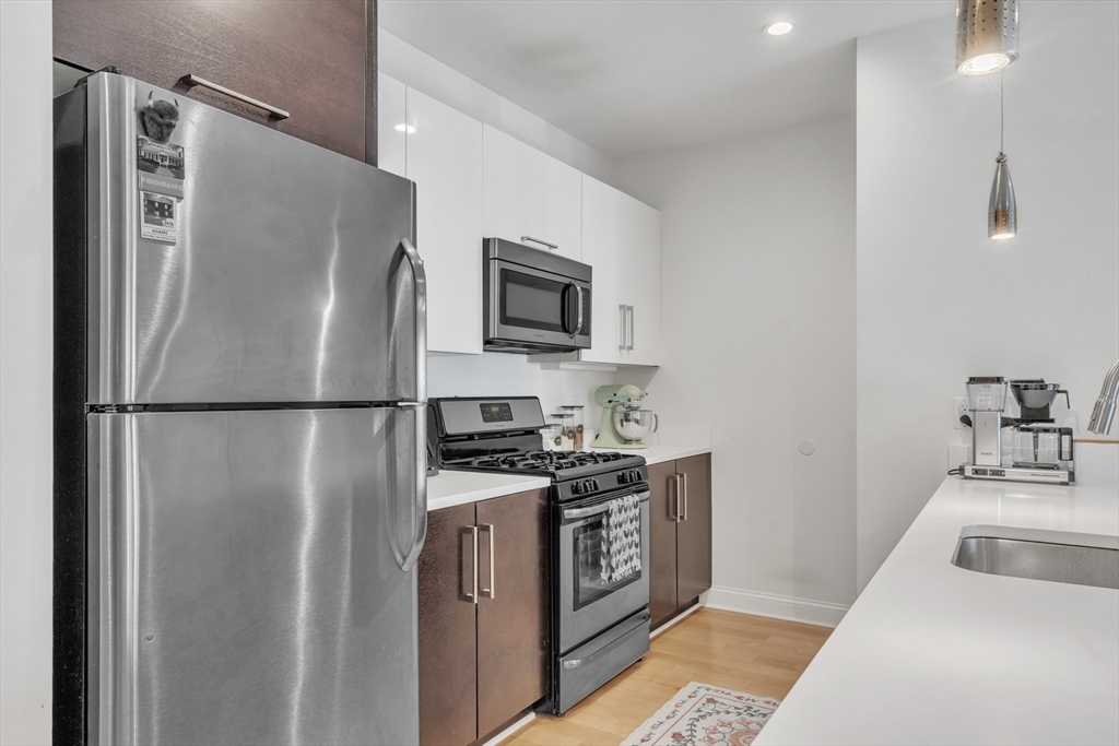 1 Brook Road, Unit 215 Quincy, MA 02169 - Photo 6 of 24 a kitchen with stainless steel appliances a refrigerator sink and microwave