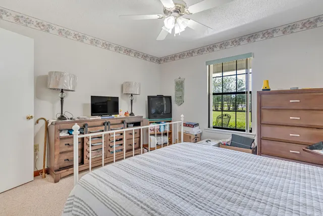 a white bed sitting in a bedroom next to a window