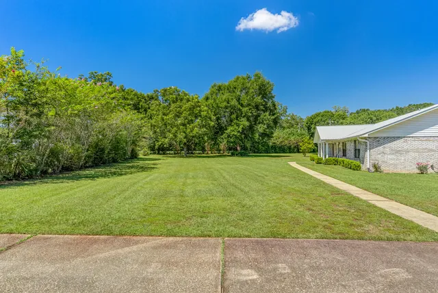 a view of a house with swimming pool lawn chairs and a yard