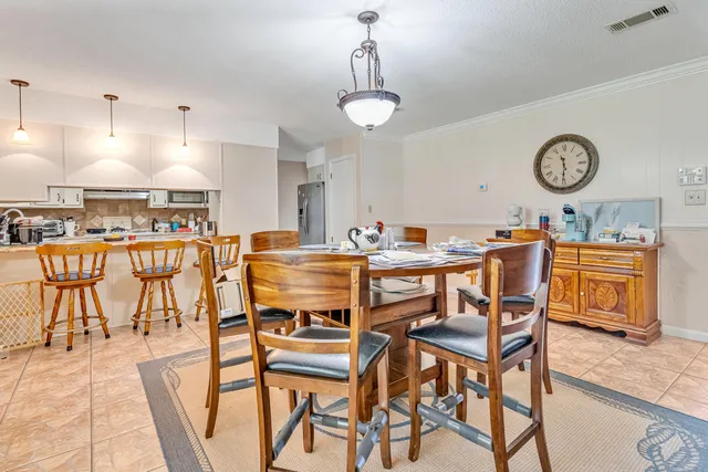 a dining room with wooden floor a chandelier a wooden table and chairs
