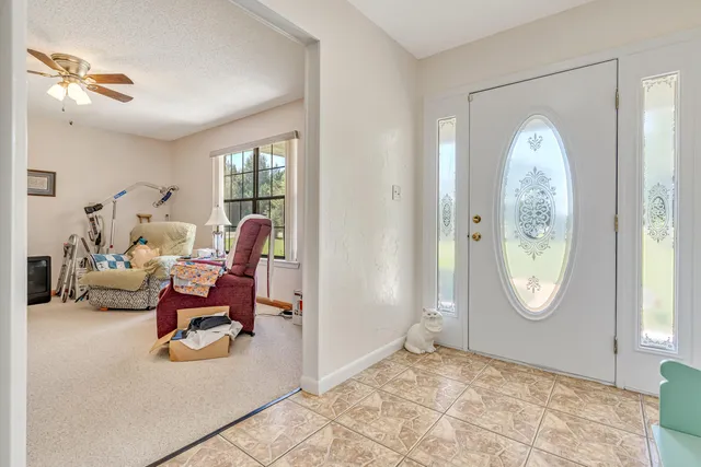 a living room with furniture a chandelier and a window