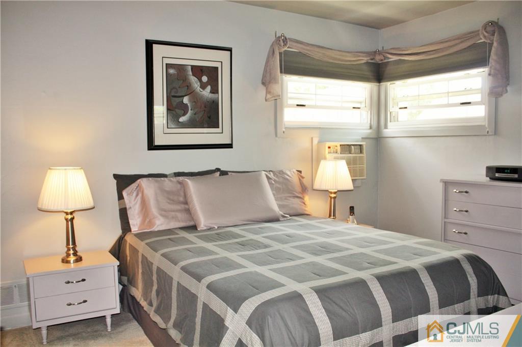 27 Ashley Road Edison, NJ 08817 - Photo 9 of 21 a bedroom with a bed and a lamp on dresser